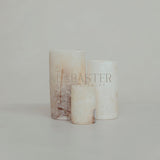 Cilinder-vormige alabaster waxinelichthouder met sfeervol licht.